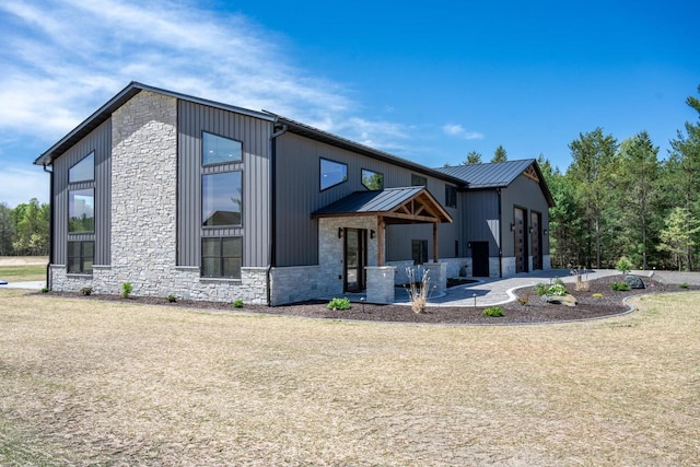 W5613 37th St, New Lisbon, WI 53950 - view of front of property with stone siding, metal roof, and a patio area