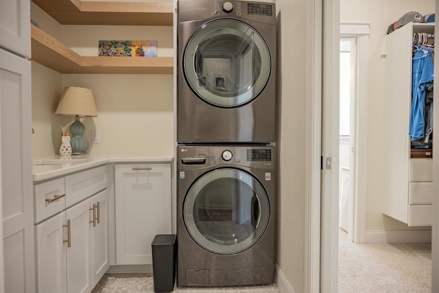 W5613 37th St, New Lisbon, WI 53950 - washroom with stacked washer and clothes dryer, cabinet space, and baseboards