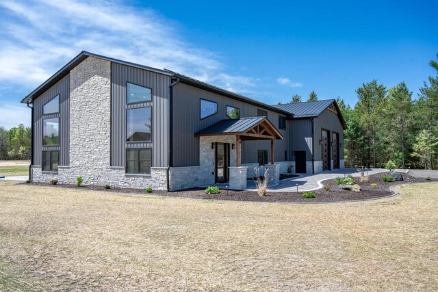 W5613 37th St, New Lisbon, WI 53950 - view of front of property with stone siding, metal roof, and a patio area