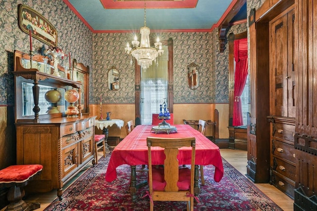 503 E Conant St, Portage, WI 53901 - dining area featuring wallpapered walls, a chandelier, wainscoting, wood finished floors, and plenty of natural light