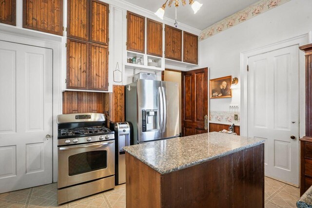 503 E Conant St, Portage, WI 53901 - kitchen with appliances with stainless steel finishes, open shelves, a center island, light stone counters, and brown cabinetry