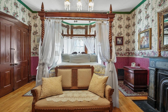 503 E Conant St, Portage, WI 53901 - living area with wallpapered walls, a wood stove, ornamental molding, a wainscoted wall, and wood finished floors