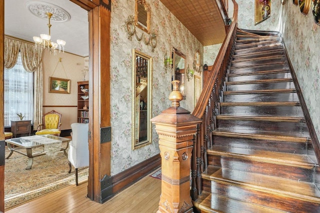 503 E Conant St, Portage, WI 53901 - stairs featuring wallpapered walls, hardwood / wood-style flooring, a chandelier, baseboards, and a wainscoted wall