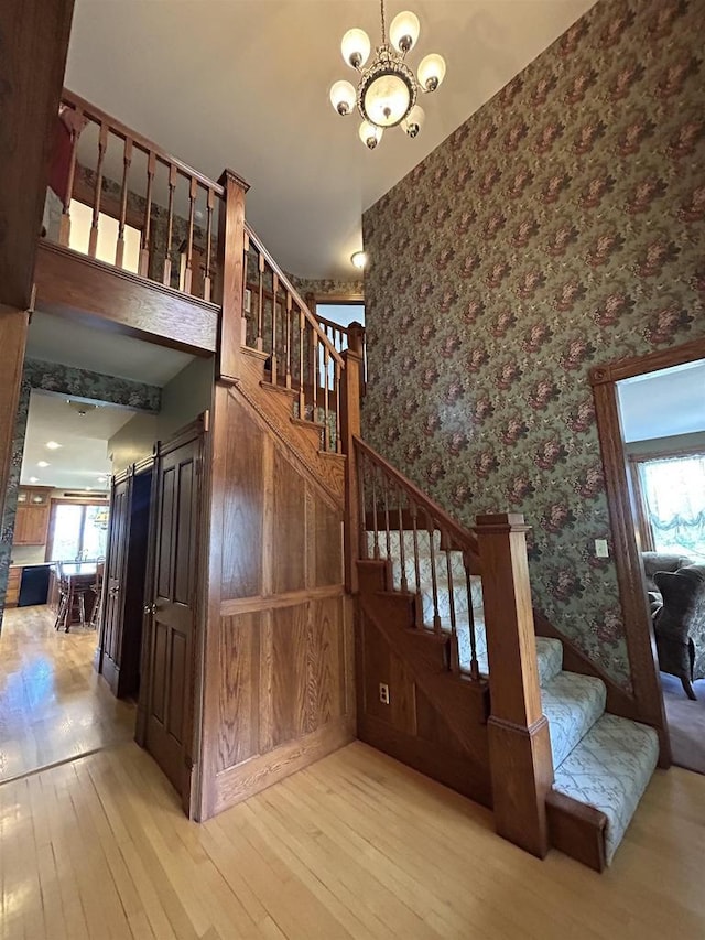 13412 Glacier Rd, Tomah, WI 54660 - stairway with wallpapered walls, a chandelier, and hardwood / wood-style floors