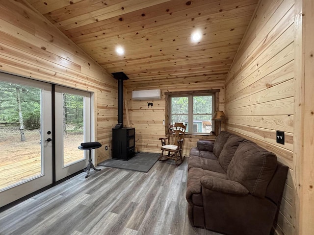 N4755 11th Dr, Montello, WI 53949 - living room featuring lofted ceiling, a wall mounted air conditioner, plenty of natural light, wood finished floors, and a wood stove