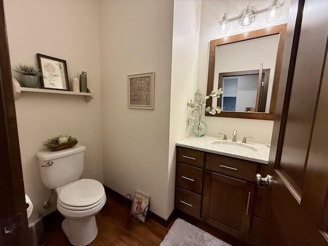 515 Fieldstone Ct, Tomah, WI 54660 - bathroom with wood finished floors, toilet, vanity, and baseboards