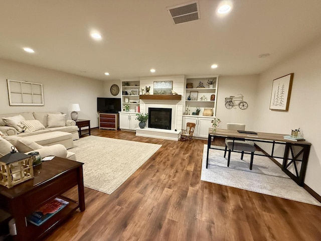 515 Fieldstone Ct, Tomah, WI 54660 - living area with recessed lighting, dark wood-style flooring, a glass covered fireplace, baseboards, and an office area