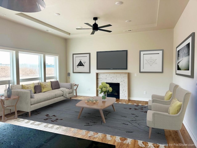 365 N Wilson St, Kimberly, WI 54136 - living area with a tray ceiling, a ceiling fan, baseboards, wood finished floors, and a fireplace