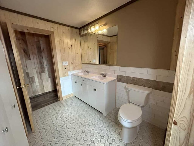 188 County Rd N, Birnamwood, WI 54414 - bathroom featuring crown molding, toilet, wood walls, a wainscoted wall, and tile walls