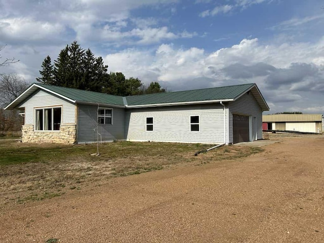 188 County Rd N, Birnamwood, WI 54414 - view of property exterior with an attached garage, metal roof, driveway, and stone siding