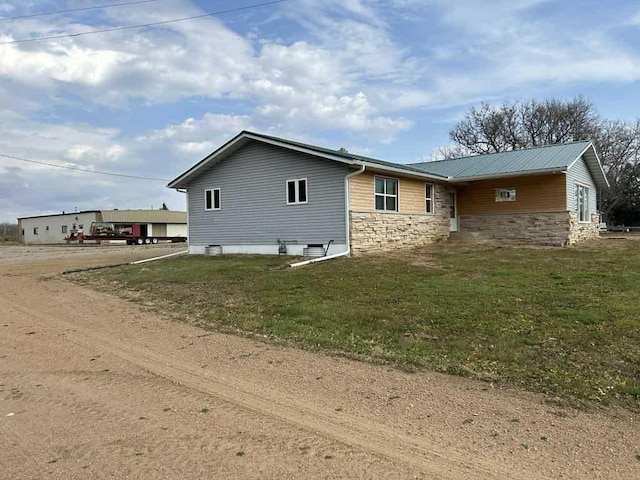 188 County Rd N, Birnamwood, WI 54414 - view of side of property featuring stone siding and a lawn