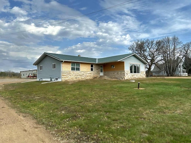 188 County Rd N, Birnamwood, WI 54414 - view of home's exterior with stone siding, a yard, and metal roof