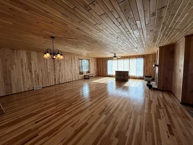 188 County Rd N, Birnamwood, WI 54414 - unfurnished living room featuring wood ceiling, wood walls, wood finished floors, and a chandelier