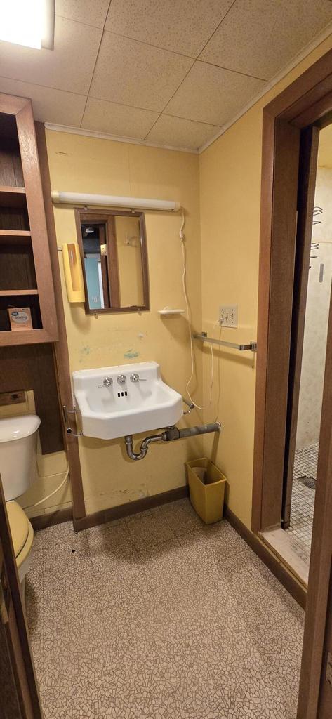 2905 S 18th St, Sheboygan, WI 53081 - half bathroom featuring a sink, toilet, baseboards, and a paneled ceiling