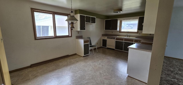 2905 S 18th St, Sheboygan, WI 53081 - kitchen with white dishwasher, tile patterned floors, a sink, baseboards, and pendant lighting