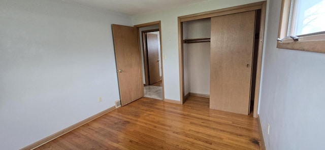 2905 S 18th St, Sheboygan, WI 53081 - unfurnished bedroom with light wood-style floors, a closet, and baseboards