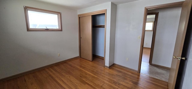 2905 S 18th St, Sheboygan, WI 53081 - unfurnished bedroom with multiple windows, wood finished floors, baseboards, and a closet