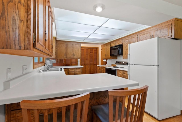 430 Fairview Way, Shawano, WI 54166 - kitchen with freestanding refrigerator, electric range oven, black microwave, a sink, and a peninsula
