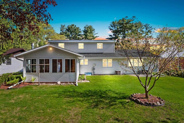 430 Fairview Way, Shawano, WI 54166 - rear view of house featuring a lawn, central AC unit, and a sunroom
