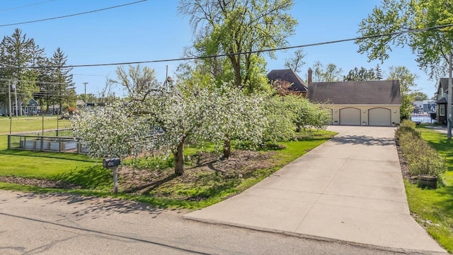 109 Doty St, Fremont, WI 54940 - view of property hidden behind natural elements featuring a garage, driveway, and a front yard