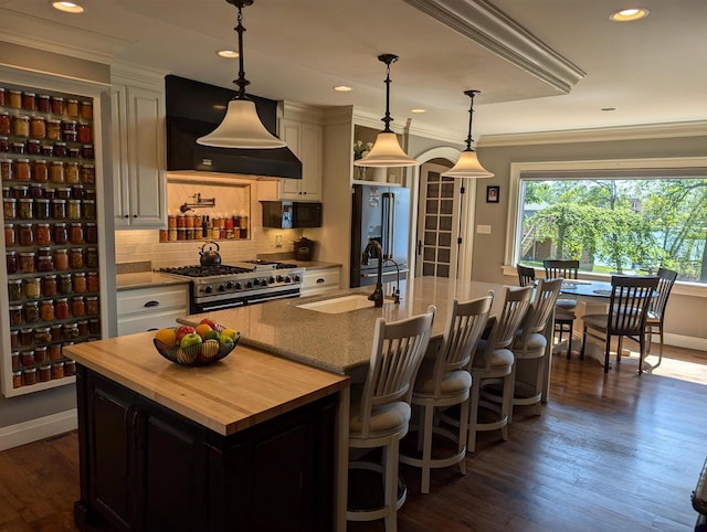 109 Doty St, Fremont, WI 54940 - kitchen with custom range hood, a sink, premium appliances, wood counters, and a large island with sink