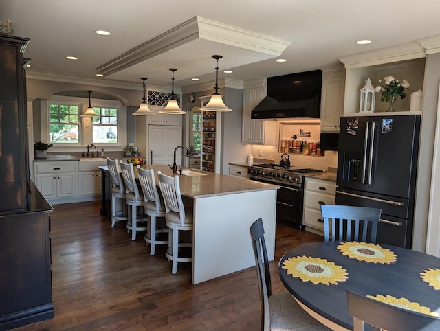 109 Doty St, Fremont, WI 54940 - kitchen with black fridge with ice dispenser, wall chimney exhaust hood, range with two ovens, a sink, and ornamental molding