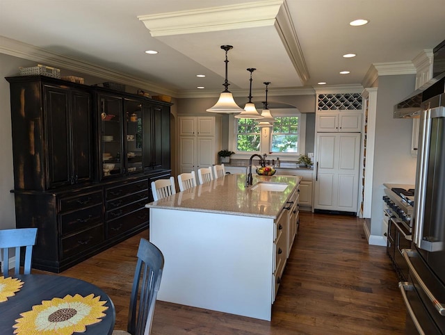 109 Doty St, Fremont, WI 54940 - kitchen featuring a sink, light stone countertops, a kitchen island with sink, white cabinets, and arched walkways