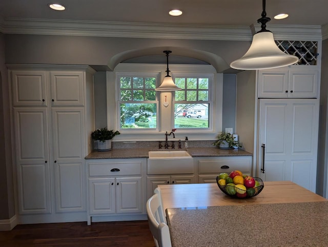 109 Doty St, Fremont, WI 54940 - kitchen featuring a sink, white cabinets, pendant lighting, ornamental molding, and dark stone countertops