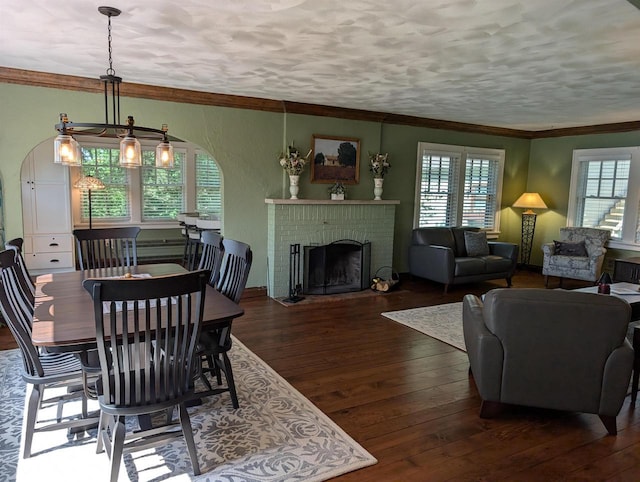 109 Doty St, Fremont, WI 54940 - dining area with wood-type flooring, arched walkways, ornamental molding, and a fireplace
