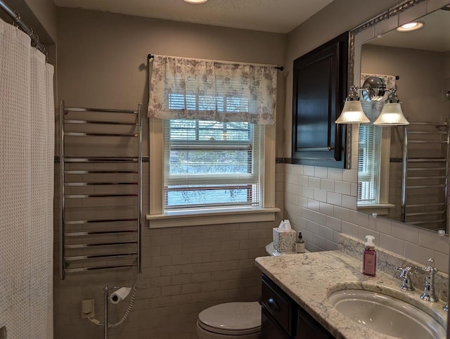 109 Doty St, Fremont, WI 54940 - bathroom with tile walls, toilet, vanity, radiator heating unit, and a shower with curtain