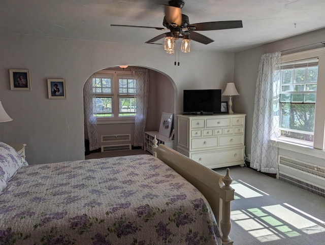 109 Doty St, Fremont, WI 54940 - carpeted bedroom featuring arched walkways, multiple windows, and radiator