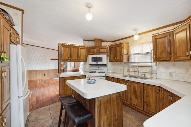 26 Westminster Ave, Holmen, WI 54636 - kitchen with white appliances, wallpapered walls, a kitchen island, light countertops, and a sink