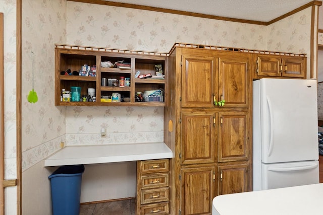 26 Westminster Ave, Holmen, WI 54636 - kitchen featuring freestanding refrigerator, wallpapered walls, brown cabinets, light countertops, and crown molding