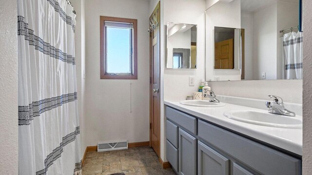 13213 138th Ave, Chippewa Falls, WI 54729 - bathroom with baseboards, double vanity, and stone finish flooring