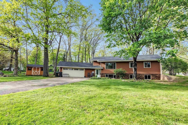 600 Honey Bear Ct, Waupaca, WI 54981 - view of front facade with asphalt driveway, a garage, a front lawn, and central AC unit