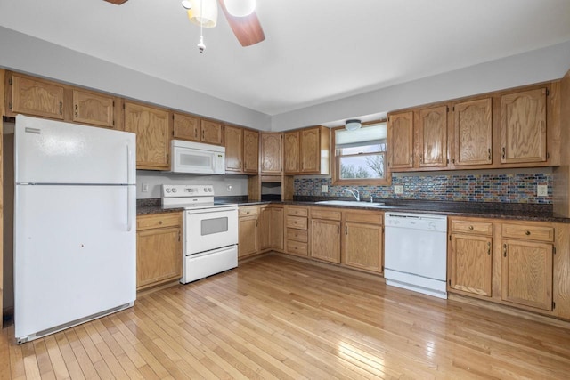 167 W Paradise Dr, West Bend, WI 53095 - kitchen featuring white appliances, a sink, dark countertops, a ceiling fan, and light wood-style floors
