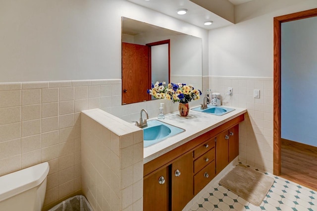 7628 W Mineral Point Rd, Verona, WI 53593 - full bathroom featuring tile walls, toilet, a wainscoted wall, and double vanity