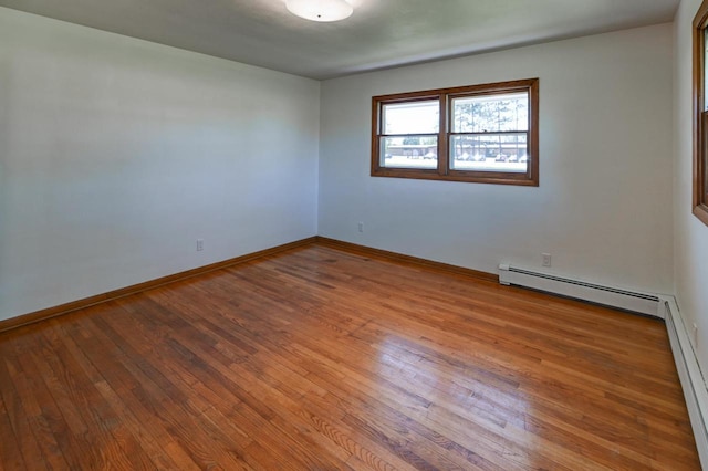 7628 W Mineral Point Rd, Verona, WI 53593 - spare room with wood finished floors, baseboards, and a baseboard heating unit