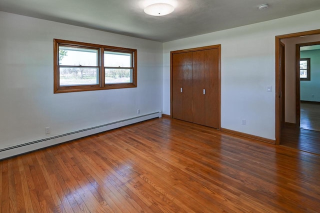 7628 W Mineral Point Rd, Verona, WI 53593 - unfurnished bedroom with baseboard heating, wood finished floors, baseboards, and a closet