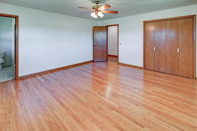 7628 W Mineral Point Rd, Verona, WI 53593 - unfurnished bedroom with light wood-style flooring, baseboards, ensuite bath, and ceiling fan