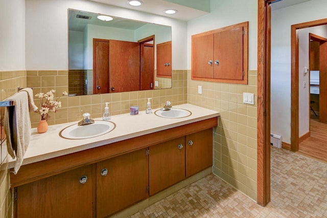 7628 W Mineral Point Rd, Verona, WI 53593 - bathroom with tile walls, baseboard heating, double vanity, and wainscoting