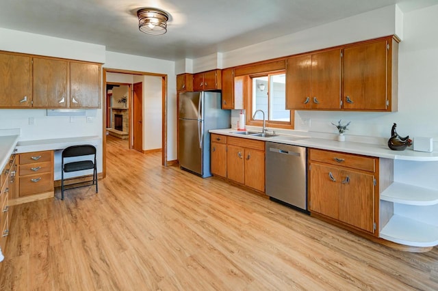 7628 W Mineral Point Rd, Verona, WI 53593 - kitchen with appliances with stainless steel finishes, a sink, light wood-style floors, and brown cabinets