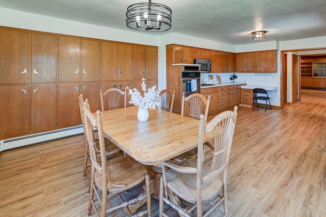 7628 W Mineral Point Rd, Verona, WI 53593 - dining space with light wood-style floors, a baseboard heating unit, and a chandelier