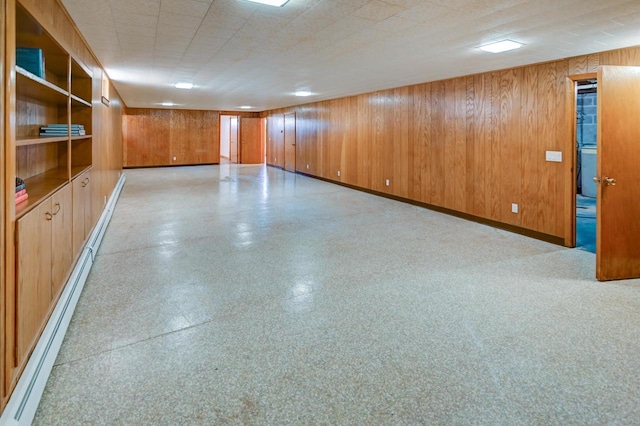 7628 W Mineral Point Rd, Verona, WI 53593 - unfurnished room with baseboards, wood walls, a baseboard radiator, and light flooring