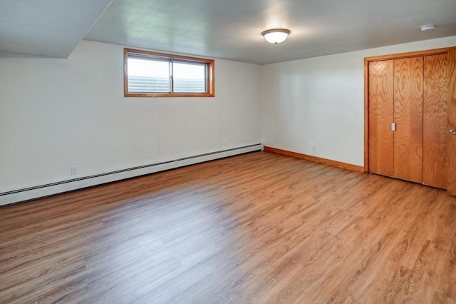 7628 W Mineral Point Rd, Verona, WI 53593 - unfurnished bedroom featuring a baseboard heating unit, light wood-type flooring, and baseboards