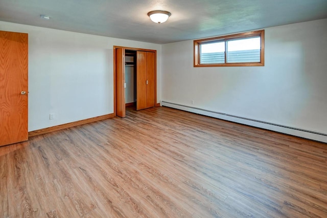 7628 W Mineral Point Rd, Verona, WI 53593 - empty room with wood finished floors, baseboards, and a baseboard heating unit