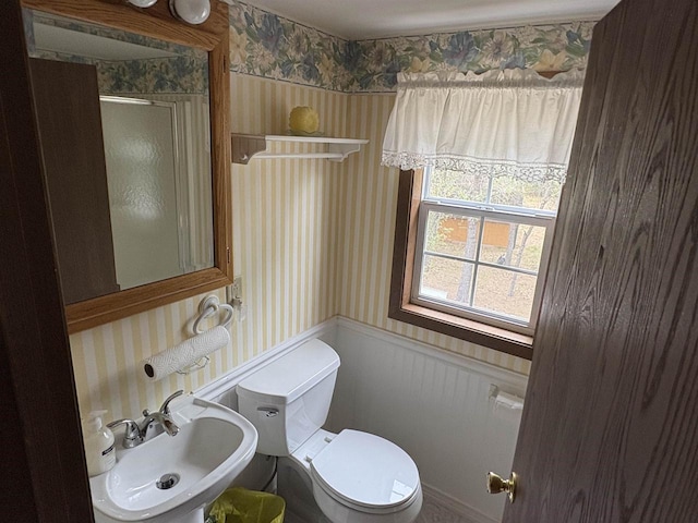 W5946 Beach Dr, New Lisbon, WI 53950 - bathroom featuring wallpapered walls, a wainscoted wall, a sink, toilet, and an enclosed shower