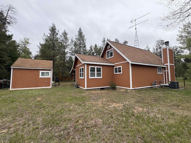 W5946 Beach Dr, New Lisbon, WI 53950 - view of side of home with cooling unit, a lawn, an outdoor structure, and a chimney