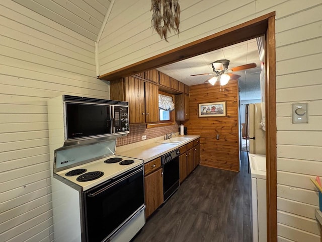 W5946 Beach Dr, New Lisbon, WI 53950 - kitchen with black appliances, a sink, wooden walls, dark wood-style floors, and brown cabinetry