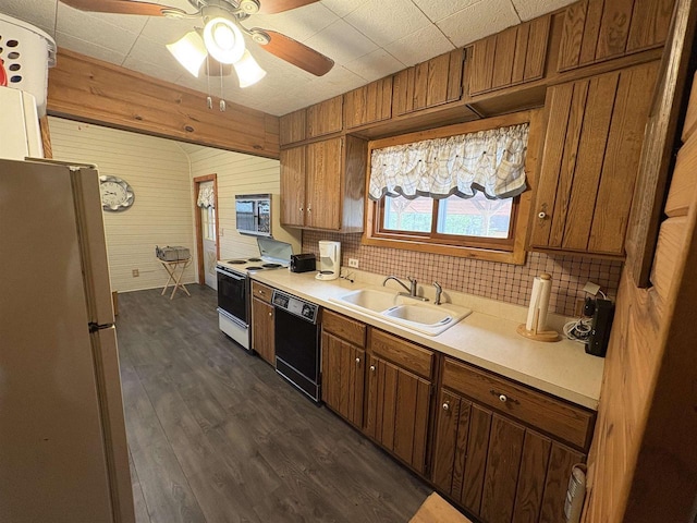 W5946 Beach Dr, New Lisbon, WI 53950 - kitchen with black dishwasher, electric range oven, freestanding refrigerator, light countertops, and wooden walls